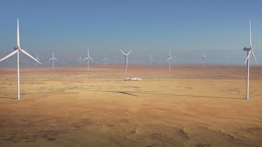 Windrunner, avião gigante da Radia, andando em pista cercado de turbinas de energia eólica