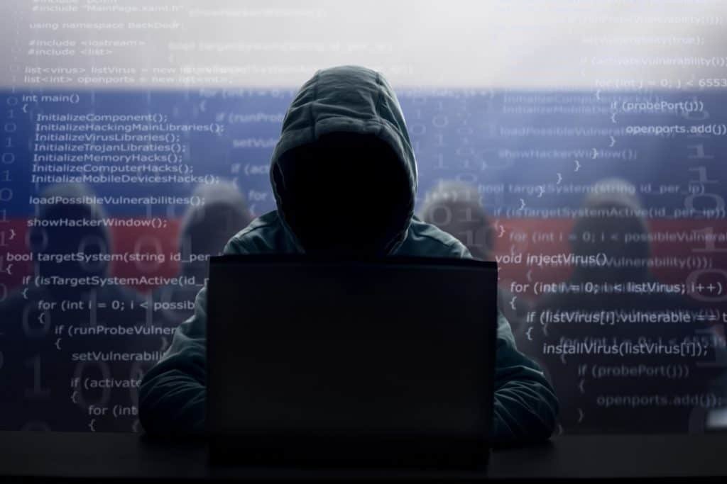 Hacker russo. Homem de capuz e máscara escura. Crimes cibernéticos. Roubo de identidade.