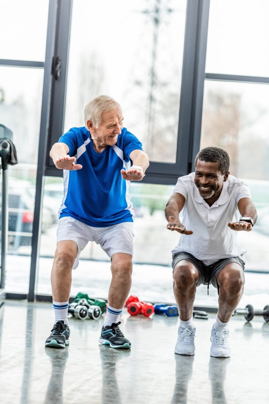 two multicultural mature sportsmen doing squats at gym